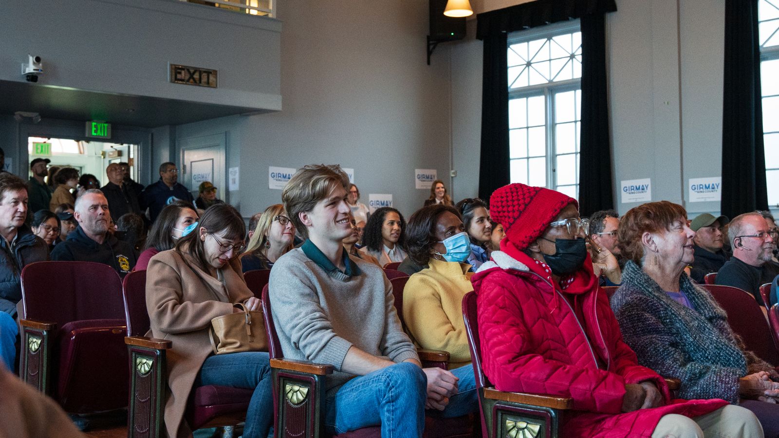 Residents seated at a community meeting listening to a speaker